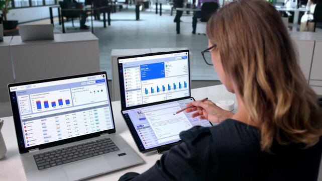 Experienced HR Manager Reviews Employee Payroll Data On Laptop