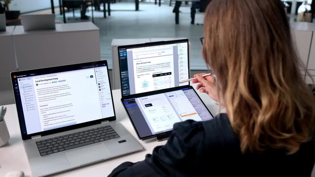 Mature Woman Organizes Digital Files On Dual Screens
