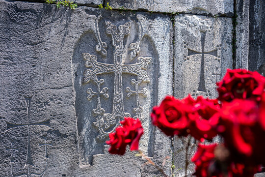 Intricate Stone Khachkar Carvings at Sanahin Monastery with Red Roses in Foreground