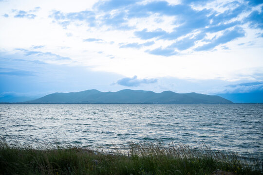 Wavy Lake Water Surface looking across to Mountain Silhouette at Dusk