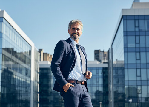 portrait of a senior businessman in front of corporate buildings
