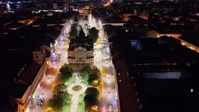 Night aerial footage of the historic center of Kosice, Slovakia, showing St. Elisabeth Cathedral, the Urban Tower and the city&rsquo;s main square. The drone view highlights the illuminated Gothic landmark 