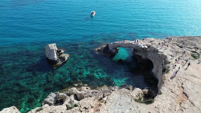 Aerial view of Love Bridge natural rock arch over turquoise sea water in Cape Greco, Cyprus