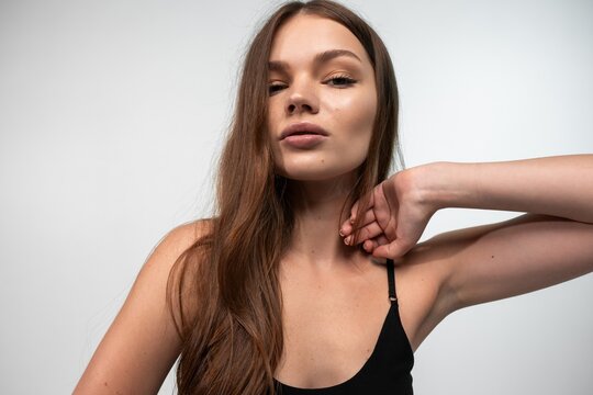 Young woman with natural appeal and long flowing hair looking at camera, posing with confident and calm expression