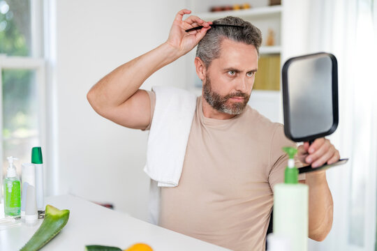 Comb and hairbrush. Brushing hair. Mature man combing hair. Hairdresser. Man with hairbrush at home. Male beauty hairstyle. Haircare and hair loss. Man use hair comb, copy space