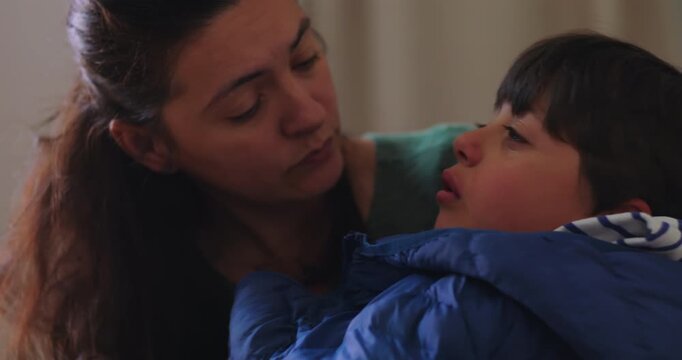 Mother listens as hurt son describes his pain while held at home, offering empathetic reassurance, gentle comfort, emotional safety and trusted connection during recovery