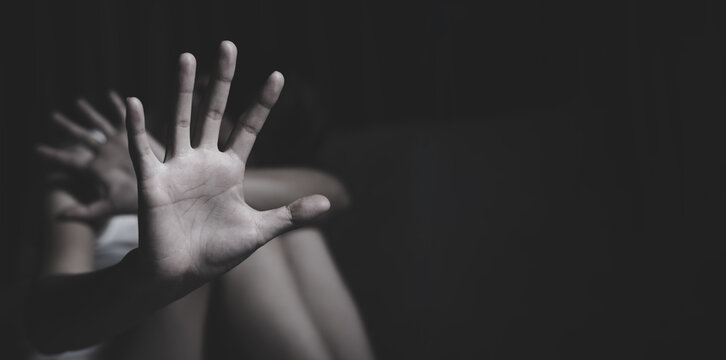 Woman raising an open hand to reject abuse and protect victims. Concept of human rights, safety, freedom, justice, and awareness against human trafficking.