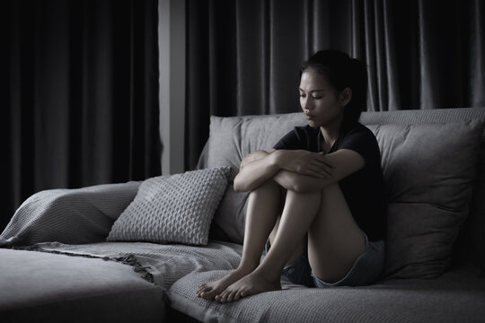 Female victim sitting alone in darkness, expressing fear, sorrow, and emotional distress. Concept of abuse, trafficking, victim support, safety, recovery, and mental health.