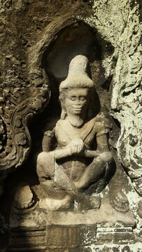 Ancient stone carving of a praying ascetic rishi sitting in a lotus position, Preah Khan temple, Angkor, Cambodia