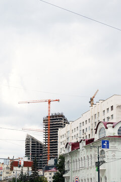 Tower crane at high rise building construction site. Urban development and residential real estate construction.
