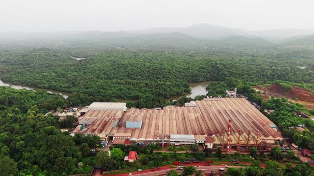 Rubber and tyre production facility surrounded by dense forest beside a river