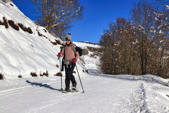 Une femme en randonn&eacute;e en raquettes de neige en hiver