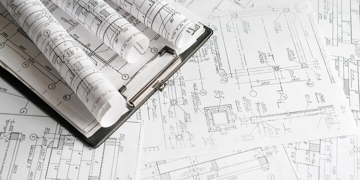 Blueprints, rolled plans and drafting tools on desk, architectural engineering workflow concept for construction planning, technical documentation, project management and building design.