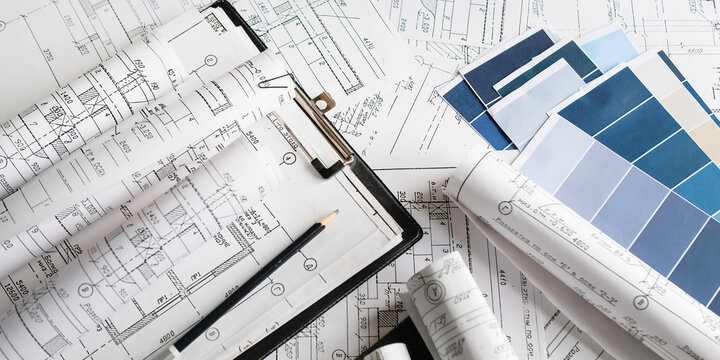 Blueprints, rolled plans and drafting tools on desk, architectural engineering workflow concept for construction planning, technical documentation, project management and building design.