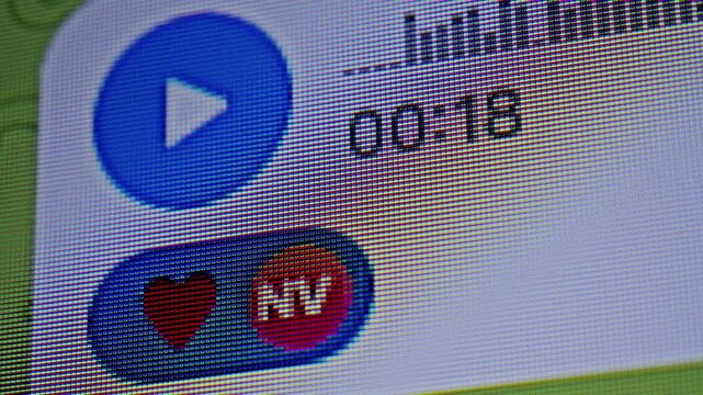 Close-up of smartphone screen with messaging app interface showing user adding a like reaction to a voice message. Audio chat interaction, digital communication and social media engagement concept