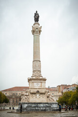 Fototapeta premium Close view of the Restauradores Monument in Lisbon, Portugal, against an overcast sky. Historic column honoring Portuguese independence in the heart of the capital city.