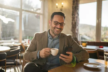 Happy man relaxing and using phone in a cafe © Miljan Živković