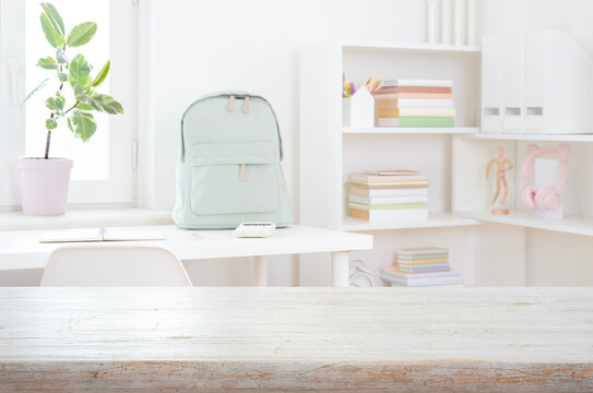 Bleached empty wooden table top on blurred modern student workspace background