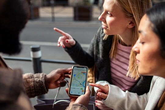 Friends using a map app on city street