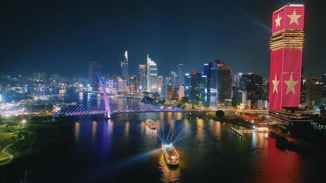 Aerial View of Dinner Cruise Boat Navigating Saigon River at Night in Ho Chi Minh City
bright boat searchlights, colorful reflections across the water, the lit-up cable-stayed bridge, glowing downtown