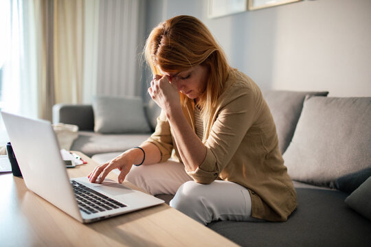 Stressed woman working on laptop at home