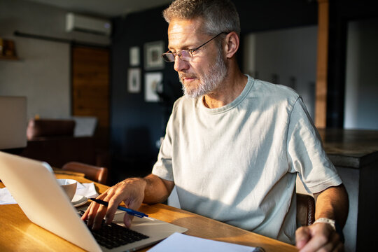 Mature man working on laptop at home office