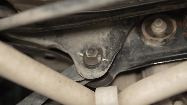 A close-up of a bolts and bushings on car suspension.