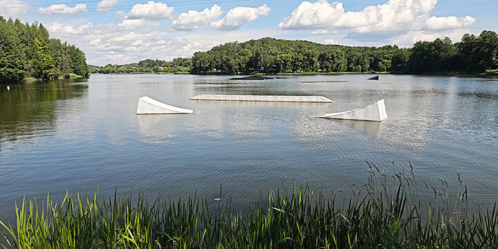 Wake park obstacles floating on a calm lake, offering a perfect setting for water sports and summer recreation