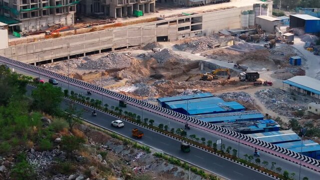 High-rise buildings construction area with road, footpath and vehicles at Makthakousarali, manikonda, hyderabad, telangana, india. day time, trucking shot, drone shot, 4k.
