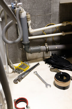 Vertical orientation plumbing tools wrench and pipes under bathroom sink installation or repair process water filtration system apartment maintenance sewage pipeline renovation home improvement handym