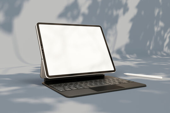 Digital tablet mockup with keyboard under natural leaf shadows