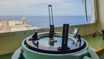 Close up view of marine azimuth circle compass repeater on ship navigation bridge overlooking ocean and vessel deck for maritime industrial travel stock photo © moryachka