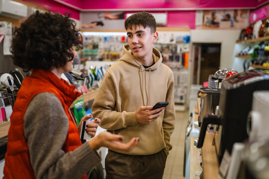 Mother and son discussing appliance purchase in electronics store