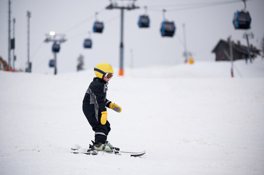 Child learning skiing on winter mountain ski slope