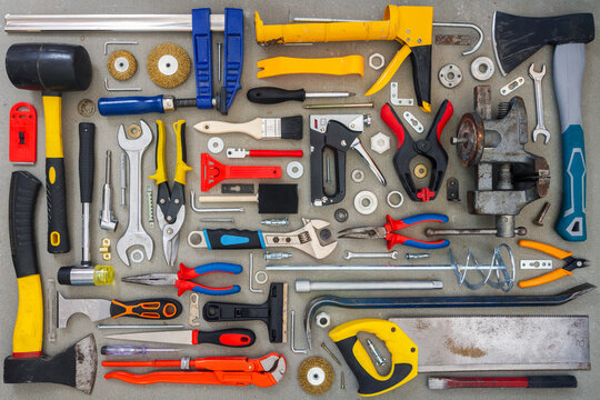 Flat lay of old and new hand tools on concrete background. Large collection of various tools and bits arranged on concrete.