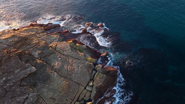 Aerial view of rocky coastline with blue ocean.