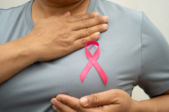 Breast cancer, pink ribbon at Asian senior lady for supporting awareness, symbol of World Breast Cancer Day.