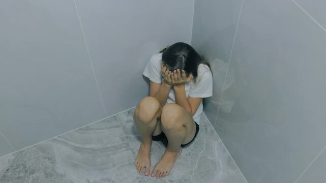 Desperate zoomer teenager sitting on floor hiding face crying.
