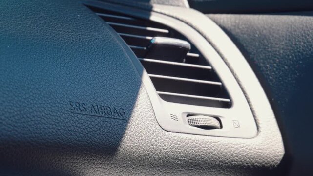 Car dashboard air vent with SRS airbag indicator close up