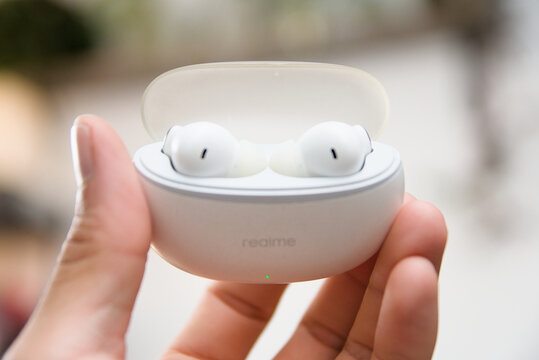 ZAPOPAN, MEXICO - JULY 30, 2026: Hand holding open Realme wireless earbuds charging case.