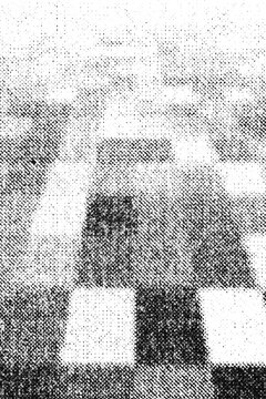 Dark and light square blocks form a blurred checkerboard halftone composition.
