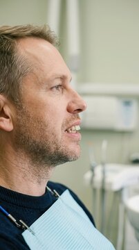 A contemplative profile portrait of a man during a clinical dental checkup