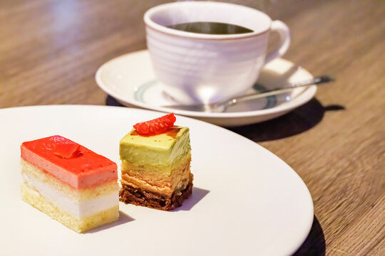 温かいホットコーヒーと奥に見えるスイーツプレート