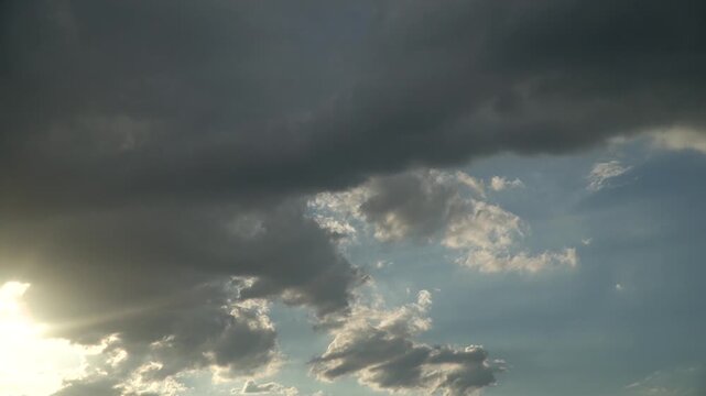 Time lapse of Dramatic Dark Clouds Moving Across a Bright Blue Sky with Sun Rays