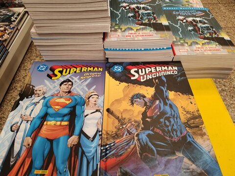 Rome, Italy - August 21, 2024, detail of covers of many classic DC Comics comics, featuring the famous superheroes Superman, Batman and Wonder Woman, on a bookstore counter.