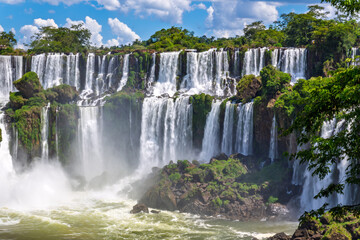Obraz premium Breathtaking scenic view of the majestic Iguazu Falls, one of the world's natural wonders, surrounded by lush tropical rainforest