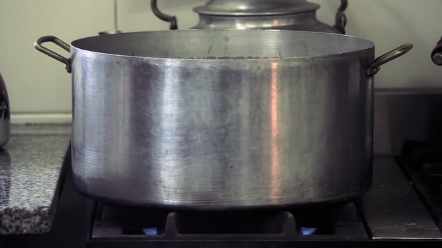 Hands Placing Pot on Stove in Argentine Public School Kitchen - 4K