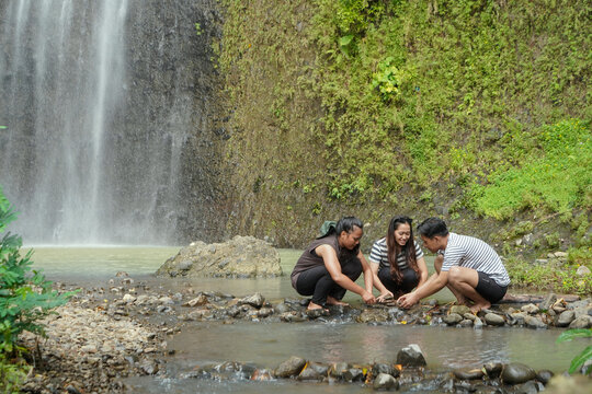 Friends Building Stone Cairn at Curug Sidoharjo Waterfall in Yogyakarta
