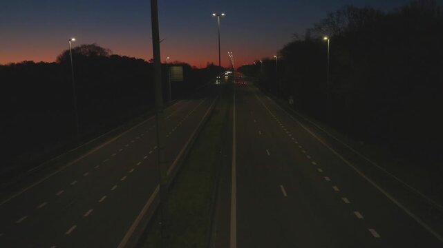 High angle view of cars driving on an illuminated highway during a beautiful sunset at blue hour