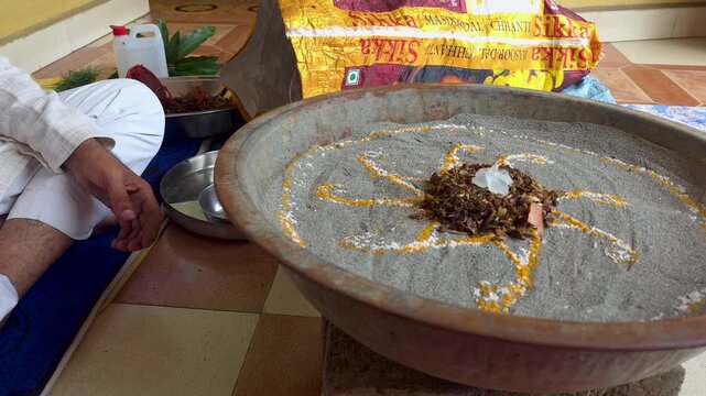 Hindu religious ceremony preparation with traditional sand pattern a close-up view of a person